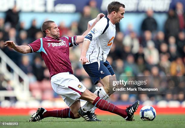 Matthew Upson of West Ham United tangles with Kevin Davies of Bolton Wanderers during the Barclays Premier League match between West Ham United and...