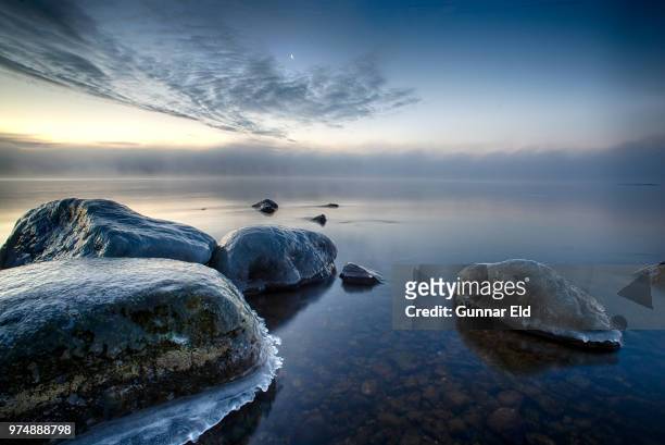 frozen rocks in sea at night, roslagen, uppland, sweden - eld stock-fotos und bilder