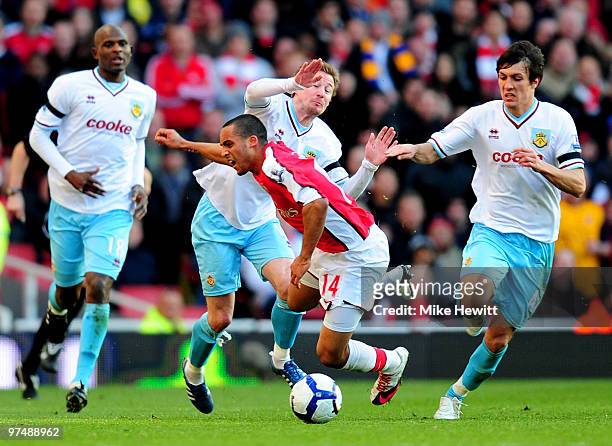 Theo Walcott of Arsenal is fouled by Wade Elliott of Burnley as Leon Cort and Jack Cork look on during the Barclays Premier League match between...