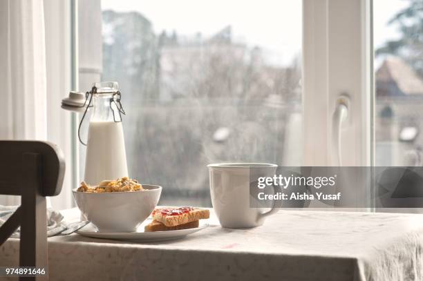 cereal, milk bottle, hot drink sandwich on table - cereal bowl stockfoto's en -beelden