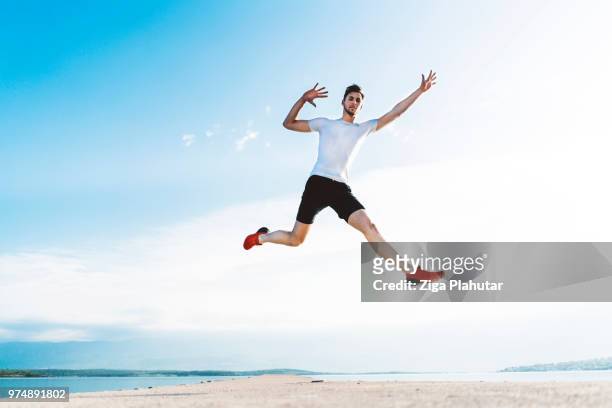 gelukkig man springen door de zee - happy jumping stockfoto's en -beelden