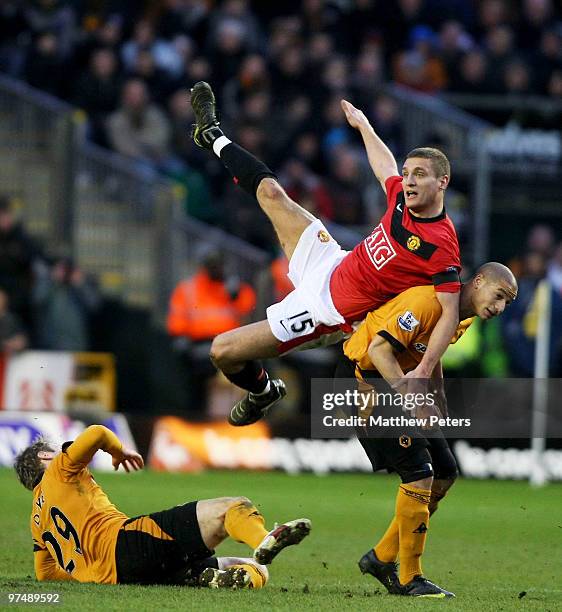 Nemanja Vidic of Manchester United clashes with Kevin Doyle and Adiene Guedioura of Wolverhampton Wanderers during the FA Barclays Premier League...