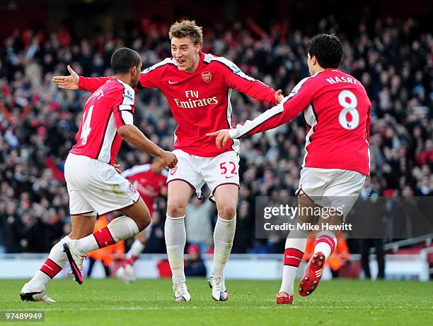 Goalscorer Theo Walcott of Arsenal is congratulated by team mates Nicklas Bendtner and Samir Nasri during the Barclays Premier League match between...