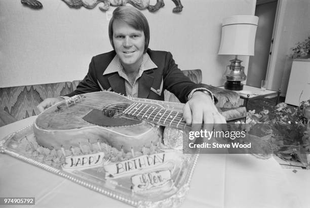 American singer, guitarist, songwriter, television host, and actor Glen Campbell with his guitar-shaped birthday cake, UK, 25th April 1973.