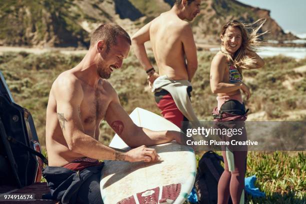 friends preparing for a surf session - surf beach stock-fotos und bilder