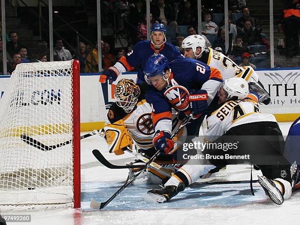 Tim Thomas of the Boston Bruins can't stop a second period goal by Josh Bailey of the New York Islanders as Kyle Okposo crashes the crease at the...