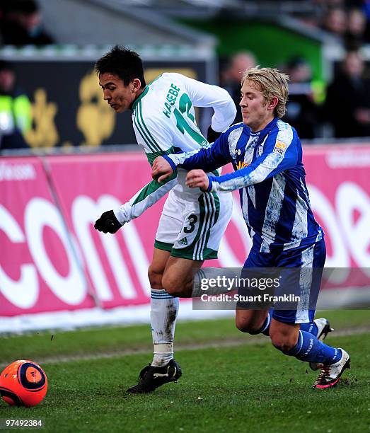 Makoto Hasebe of Wolfsburg is challenged by Lewis Holtby of Bochum during the Bundesliga match between VfL Wolfsburg and VfL Bochum at Volkswagen...