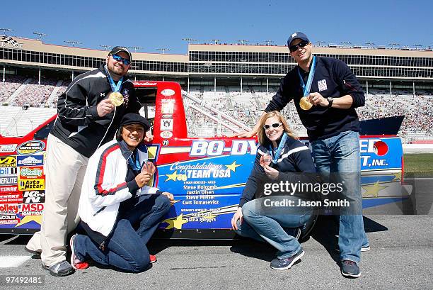 United States woman's bobsled driver Erin Pac , kneels along side team brakeman Elana Meyers , men's bobsled team pilot Steve Holcomb and pushman...