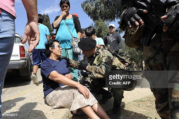 Chilean soldier aids an elderly woman as local residents hurry to the hills after a rumour of another tsunami spread in Constitucion, some 300 km...