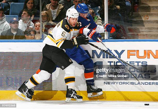 Dennis Wideman of the Boston Bruins checks Josh Bailey of the New York Islanders on February 6, 2010 at Nassau Coliseum in Uniondale, New York....