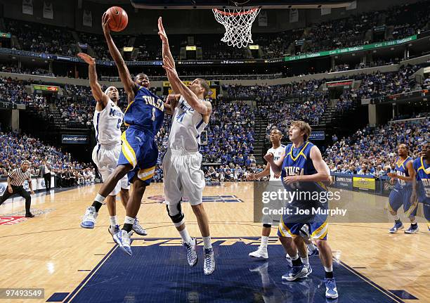 Ben Uzoh of the Tulsa Golden Hurricane drives to the basket for a layup between Roburt Sallie and Angel Garcia of the Memphis Tigers on March 6, 2010...