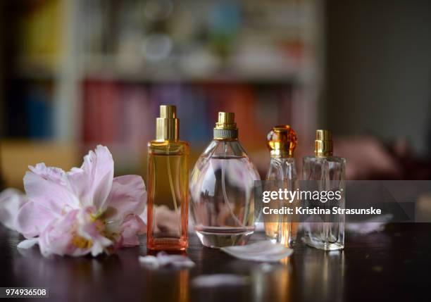 perfume bottles in summery colors and peony petals - lekker ruikend stockfoto's en -beelden