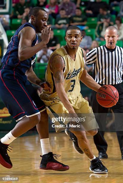 Chris Howard of the South Florida Bulls drives against Donnell Beverly of the Connecticut Huskies during the game at the SunDome on March 6, 2010 in...