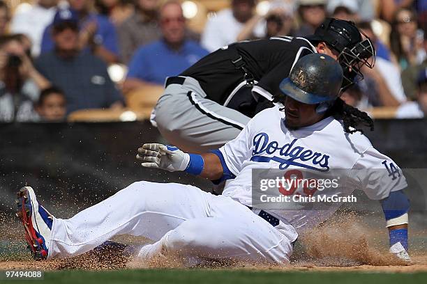 Manny Ramirez of the Los Angeles Dodgers slides home to score off a single by teammate Casey Blake against the Chicago White Sox during a spring...