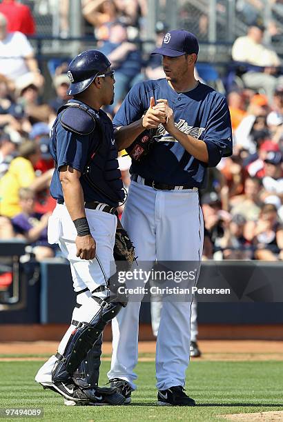 Starting pitcher Jon Garland of the San Diego Padres talks with catcher Yorvit Torrealba during a break from the MLB spring training game against the...