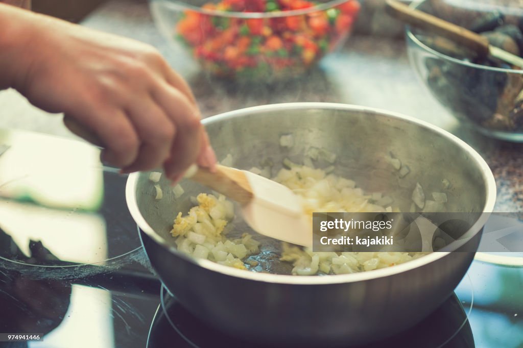 Junge Frau bereitet Paella
