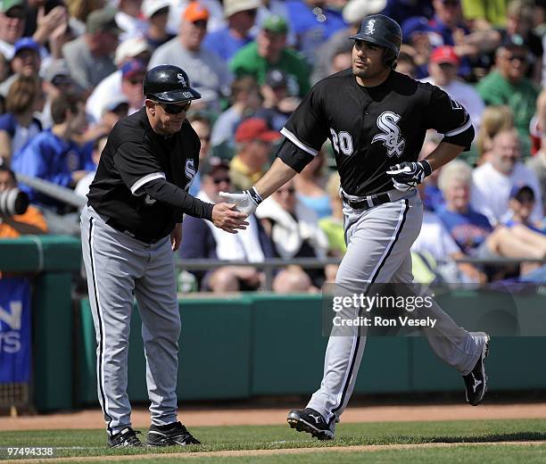 Carlos Quentin celebrates with third base coach Jeff Cox of the Chicago White Sox after hitting the first of 2 home runs against the Chicago Cubs on...