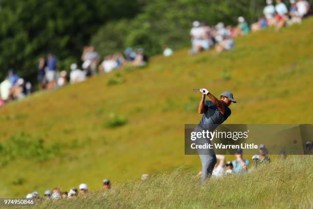 Tiger Woods of the United States plays his second shot on the 14th hole during the first round of the 2018 U.S. Open at Shinnecock Hills Golf Club on...