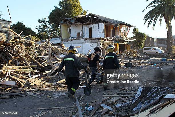 Firefighters prepare to move to another spot after searching for bodies following the massive earthquake and tsunami a week ago that killed a still...