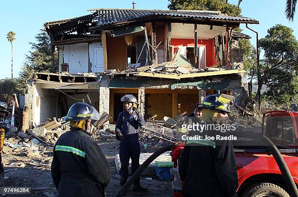 Firefighters prepare to move to another spot after searching for bodies following the massive earthquake and tsunami a week ago that killed a still...