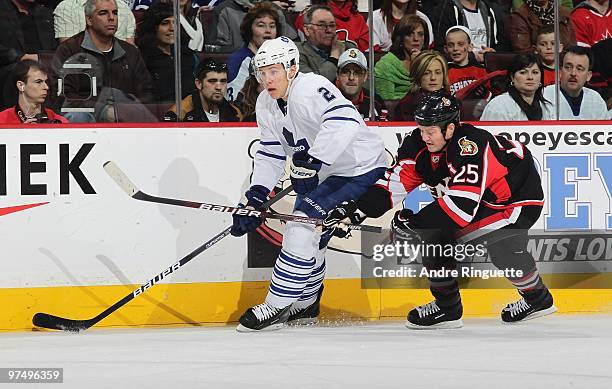 Chris Neil of the Ottawa Senators skates hard on the forecheck against Luke Schenn of the Toronto Maple Leafs at Scotiabank Place on March 6, 2010 in...