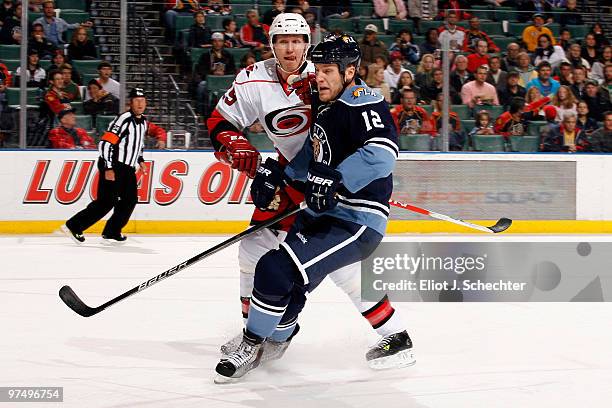 Byron Bitz of the Florida Panthers tangles with Joni Pitkanen of the Carolina Hurricanes at the BankAtlantic Center on March 6, 2010 in Sunrise,...