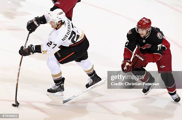 Scott Niedermayer of the Anaheim Ducks passes the puck under pressure from Radim Vrbata of the Phoenix Coyotes during the first period of the NHL...