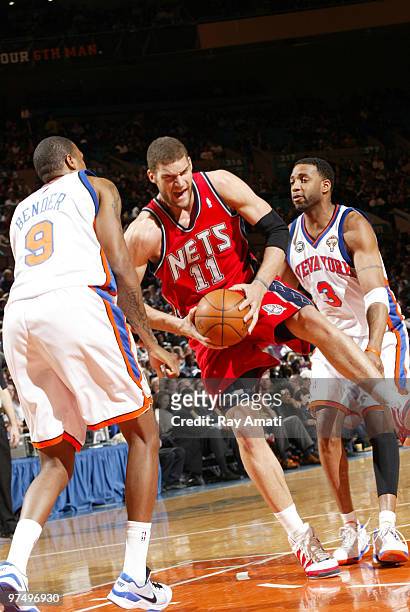 Brook Lopez of the New Jersey Nets rebounds against Jonathan Bender and Tracy McGrady of the New York Knicks on March 6, 2010 at Madison Square...