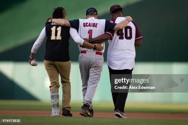Rep Steve Scalise is helped to second base by US Capitol Police Officers David Bailey and Crystal Griner during the Congressional Baseball Game on...