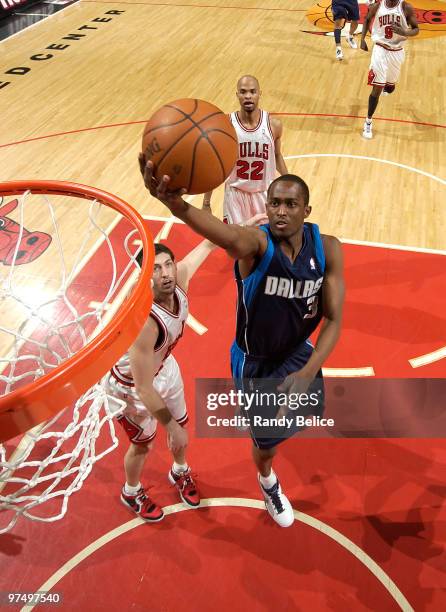 Rodrique Beaubois of the Dallas Mavericks takes the ball to the hoop, past Kirk Hinrich and Taj Gibson of the Chicago Bulls during the NBA game on...