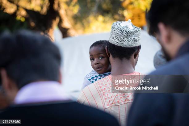 Yound boy and his father wait outside Lakemba Mosque on June 15, 2018 in Sydney, Australia. The religious Eid al-Fitr festival is celebrated for...