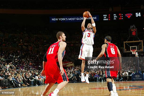 Tracy McGrady of the New York Knicks shoots against Brook Lopez and Courtney Lee of the New Jersey Nets on March 6, 2010 at Madison Square Garden in...