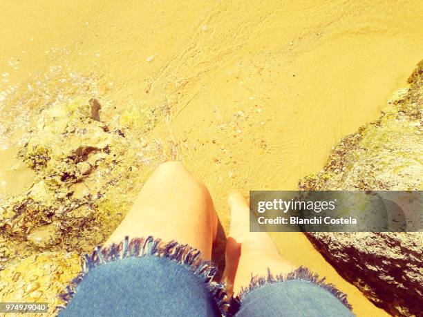 low section of woman sitting on the beach in spring - el-puerto-de-santa-maría photos et images de collection
