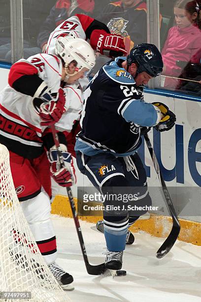 Bryan McCabe of the Florida Panthers tangles with Jussi Jokinen of the Carolina Hurricanes at the BankAtlantic Center on March 6, 2010 in Sunrise,...