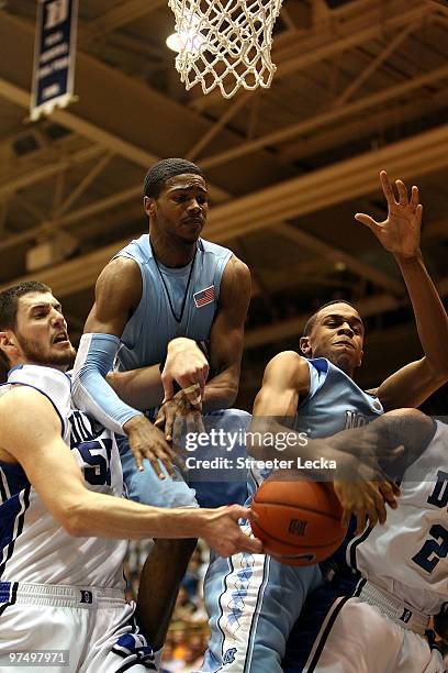 Teammates Dexter Strickland and John Henson of the North Carolina Tar Heels try to take the ball from Brian Zoubek of the Duke Blue Devils during...
