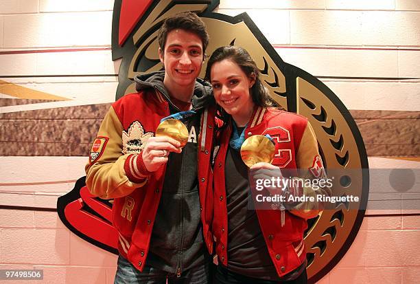 Olympic gold medalists Scott Moir and Tessa Virtue pose with their medals in the players' tunnel prior to a game between the Ottawa Senators and the...
