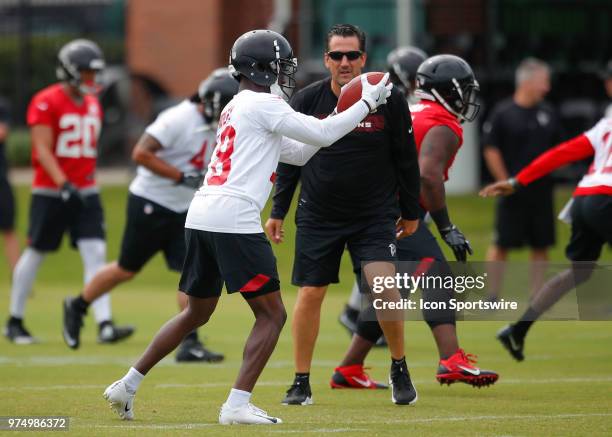 Atlanta Falcons wide receiver Calvin Ridley runs through a drill as quarterbacks coach Greg Knapp watches on during Atlanta Falcons minicamp at...