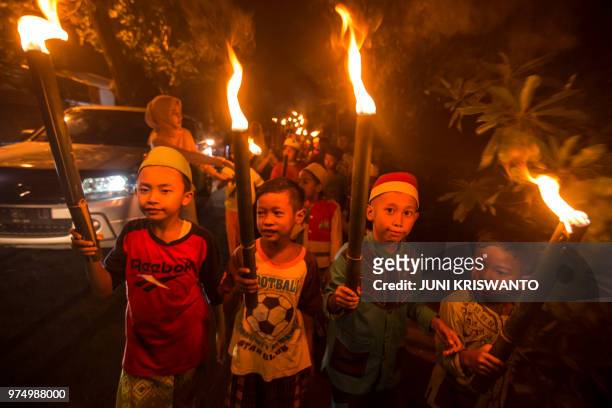 This picture taken on June 14, 2018 shows Indonesians parading on the eve of Eid al-Fitr festival in Surabaya. - Indonesia, the world's most populous...