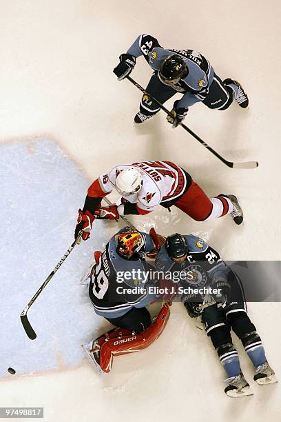 Goaltender Tomas Vokoun of the Florida Panthers and teammate Bryan McCabe defend the net against Brandon Sutter of the Carolina Hurricanes at the...