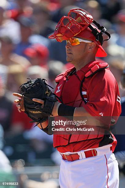 Ramon Hernandez of the Cincinnati Reds waits for play to resume against the Cleveland Indians during a spring training game at Goodyear Ballpark on...