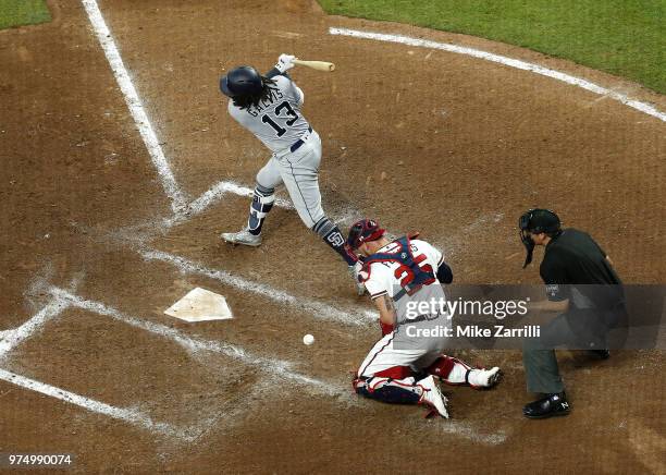 Shortstop Freddy Galvis of the San Diego Padres strikes out in the seventh inning and catcher Tyler Flowers of the Atlanta Braves blocks the pitch...