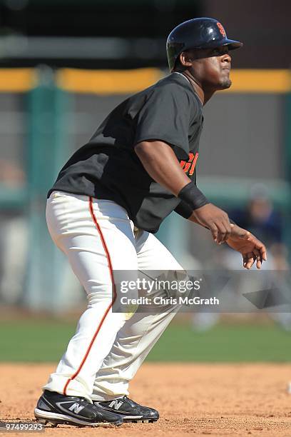 Juan Uribe of the San Francisco Giants runs between bases against the Milwaukee Brewers during a spring training game at Scottsdale Stadium on March...