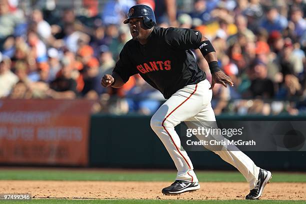 Juan Uribe of the San Francisco Giants runs between bases against the Milwaukee Brewers during a spring training game at Scottsdale Stadium on March...