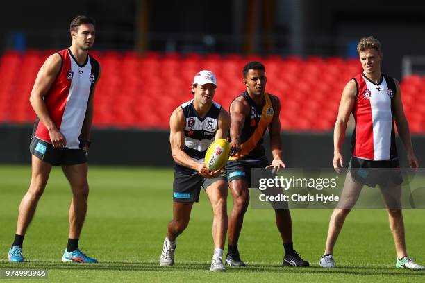 Lachie Weller handballs during a Gold Coast Suns AFL training session at Metricon Stadium on June 15, 2018 in Gold Coast, Australia.