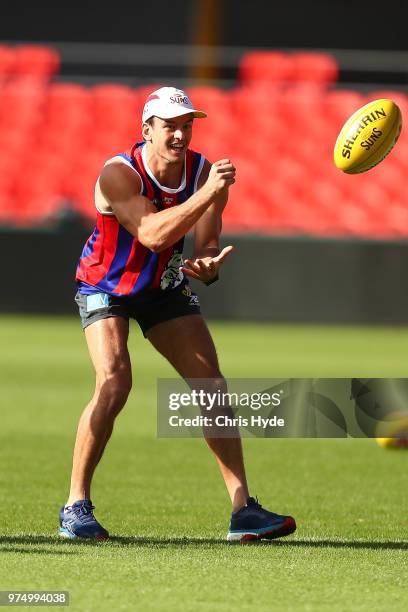 Jarryd Lyons handballs during a Gold Coast Suns AFL training session at Metricon Stadium on June 15, 2018 in Gold Coast, Australia.