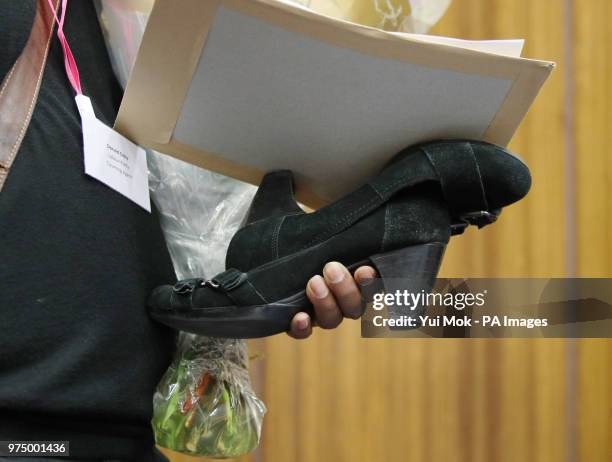 Labour candidate Janet Daby's shoes are carried by her husband Donald, after she won the Lewisham East parliamentary by-election at Lewisham Civic...