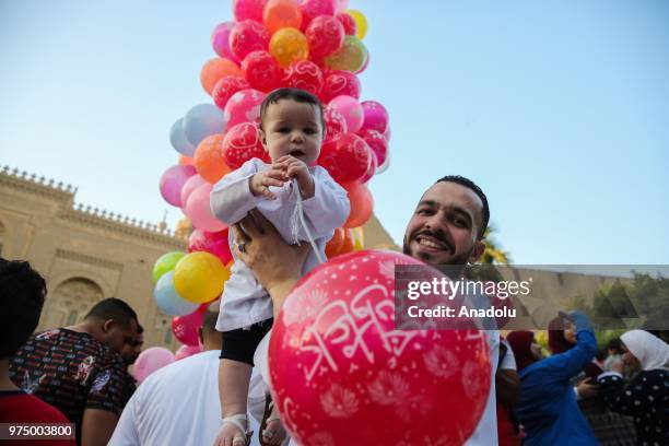 Man poses for a photo with his child after performed Eid al-Fitr prayer at Mosque-Madrassa of Sultan Hassan in Cairo, Egypt on June 15, 2018. Eid...