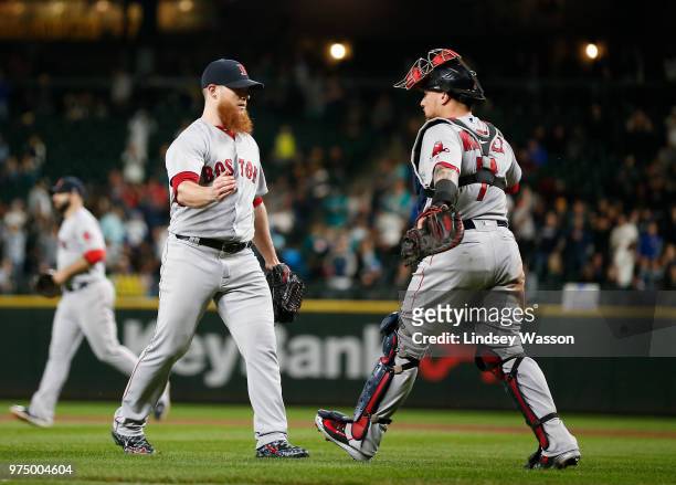 Craig Kimbrel of the Boston Red Sox is greeted by Christian Vazquez after securing the win against the Seattle Mariners at Safeco Field on June 14,...