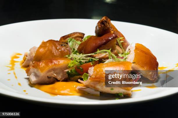 The Cochinillo "Ola", suckling pig with orange caramel and sweet & sour sauce, is prepared at Ola Cocina del Mar in Singapore, on Thursday, June 7,...