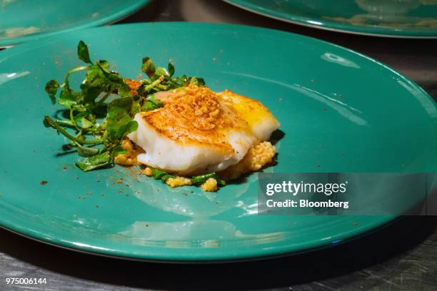 Wild Market Fish, with creamy cous cous sundried tomatoes, crispy garlic and watercress, is prepared at Ola Cocina del Mar in Singapore, on Thursday,...